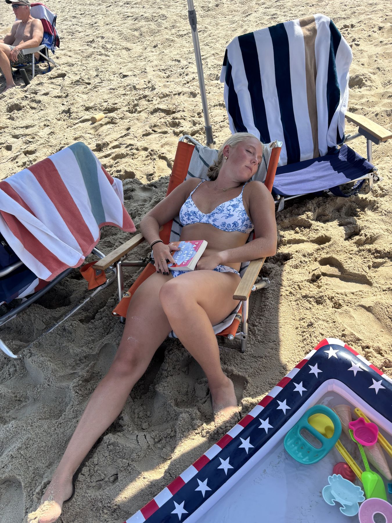 Lane asleep on the beach with her book