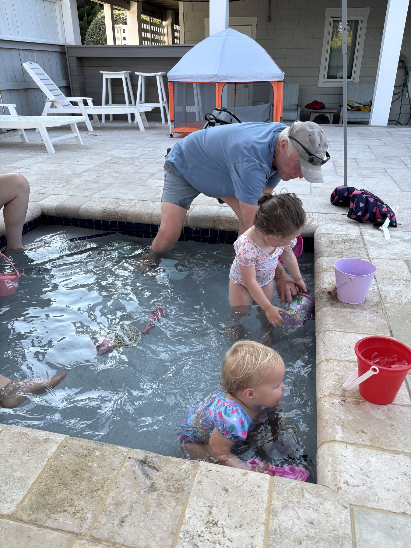 Dad and the girls on the pool ledge